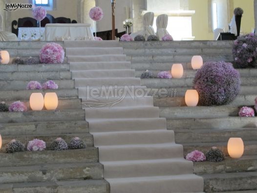 Composizione floreale lilla con sfere di fiori e candele
