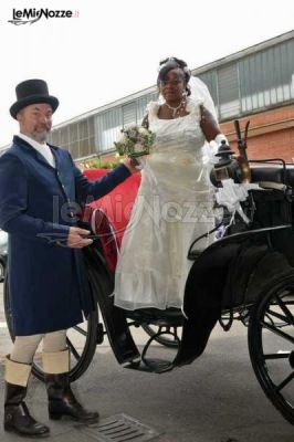 La sposa scende dalla carrozza aiutata dal cocchiere in livrea