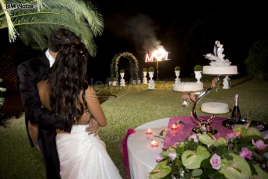 Gli sposi durante il taglio della torta con fuochi d'artificio